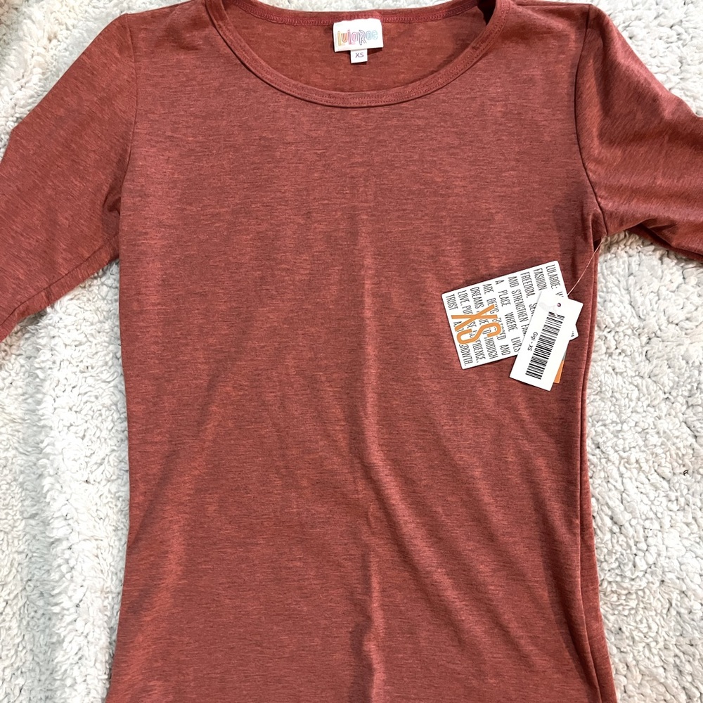 LuLaRoe GiGi is a short sleeve top. 96% polyester and 4% spandex. Burnt Orange